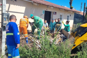 Funcionários públicos fazem a limpeza de um terreno baldio no município de Pontal do Paraná, no litoral do estado