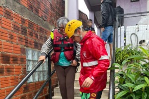 Bombeiro auxilia mulher a descer escadas