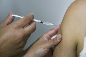 Agulha com vacina é introduzida em braço