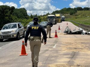 Policial Rodoviário Federal caminha pelo acostamento em direção a motocicleta caída