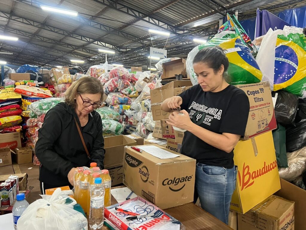 Duas mulheres empacotam doações destinadas ao Rio Grande do Sul