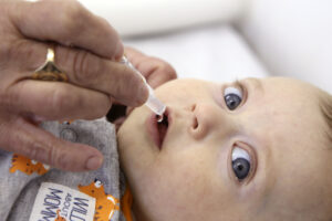 Bebê recebe "gotinha", vacina contra a poliomelite em forma líquida.