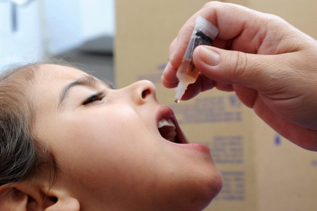 Criança recebe vacina oral contra a poliomelite.