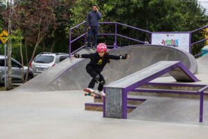 Criança faz manobra de skate em pista de skate