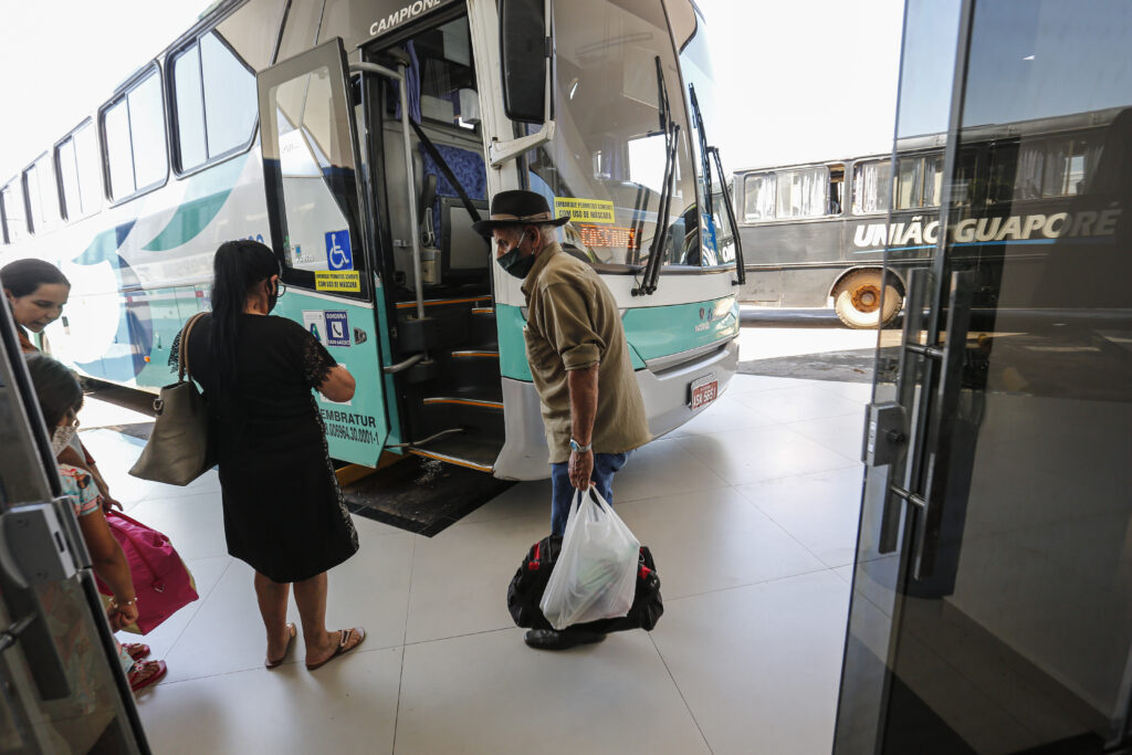 Pessoa de aparência idosa espera para subir em ônibus