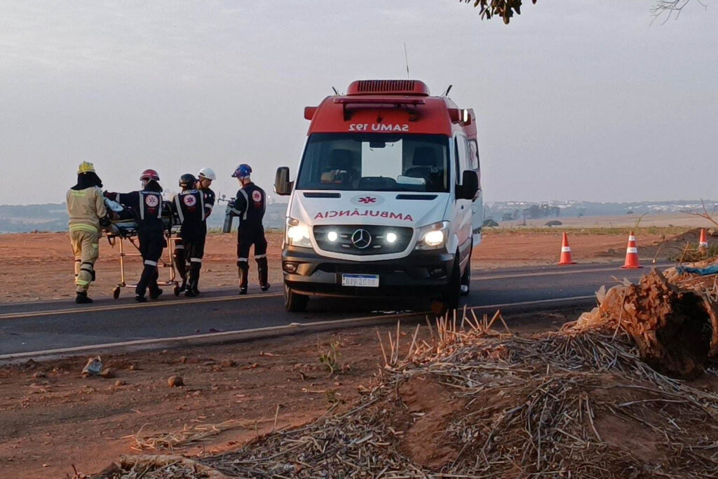 Ambulância do Samu com paramédicos e paciente sendo transportado para a lateral da ambulância