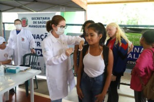 Profissional de saúde aplica vacina em braço de pessoa
