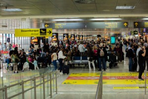 Terminal do aeroporto Afonso Pena com vários passageiros circulando