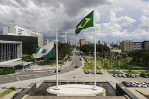 Dois mastros brancos para pendurar bandeiras. O mastro da esquerda leva a bandeira do Paraná, ela está na metade da altura total do mastro. A bandeira da direita é a bandeira do Brasil, ela está pendurada na altura completa do mastro.