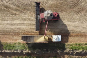 Foto aérea de caminhão agrícola despejando soja em caminhão de carga