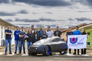 Equipe de estudantes posa atrás de veículo movido a hidrogenio