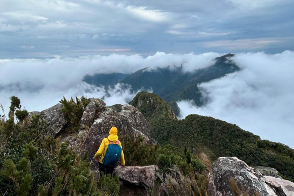 Pessoa desce trilha em topo de montanha