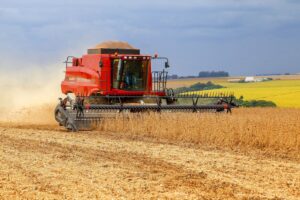 Colheitadeira passa por campo de soja