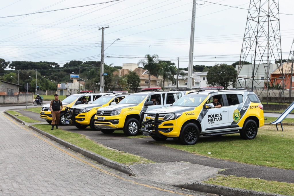 Viaturas alinhadas em gramado próximo à rua