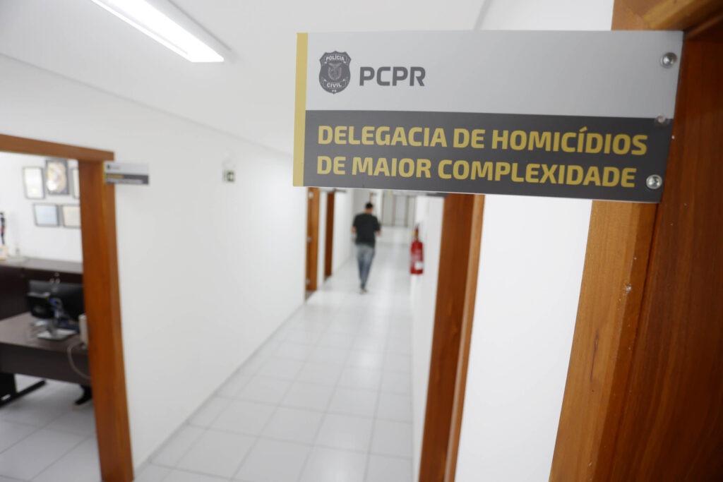 Placa instalada em topo de porta. Está escrito na placa: Delegacia de homicídios de maior complexidade