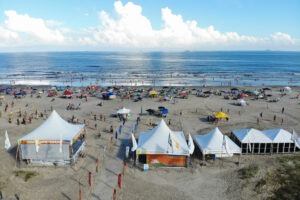 Beira de praia com barracas e banhistas