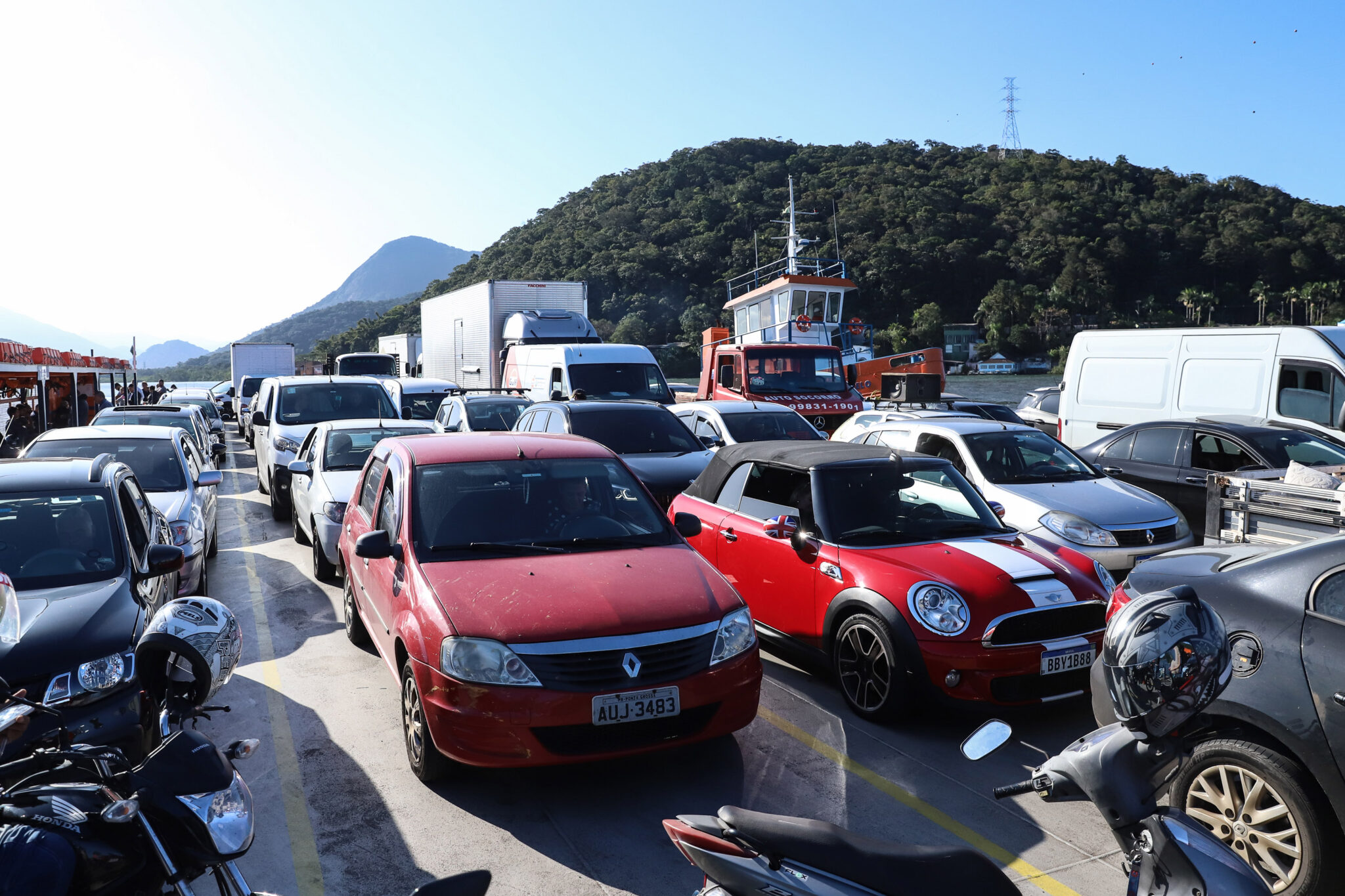 Vários carros em balsa de travessia aquática.