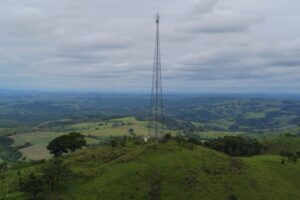 Torre de telefonia instalada em área rural e verde.