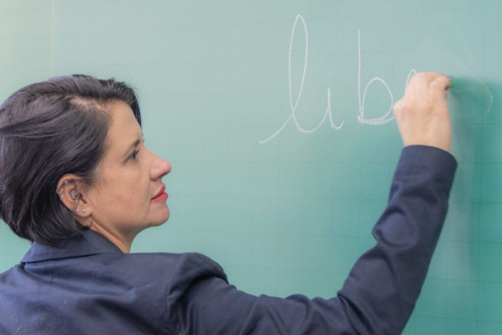 Professora escreve em um quadro negro