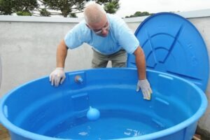 Homem faz a limpeza da caixa d'água