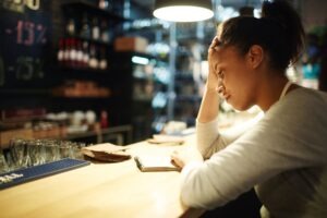 Mulher confere anotações em bloco em um balcão de bar