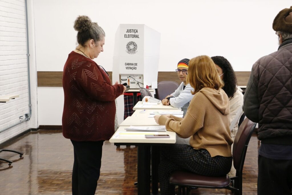 Mesários atendem uma senhora em uma seção eleitoral durante as eleições de 2022