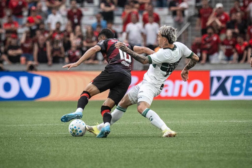 Jogadores de Athletico e Coritiba disputam uma jogada no clássico entre os times, disputado na Arena da Baixada