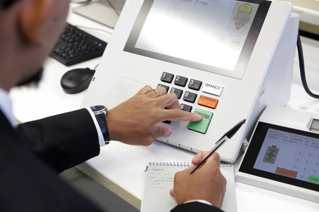 Homem programa uma urna eletrônica, do modelo que será usado nas eleições 2026