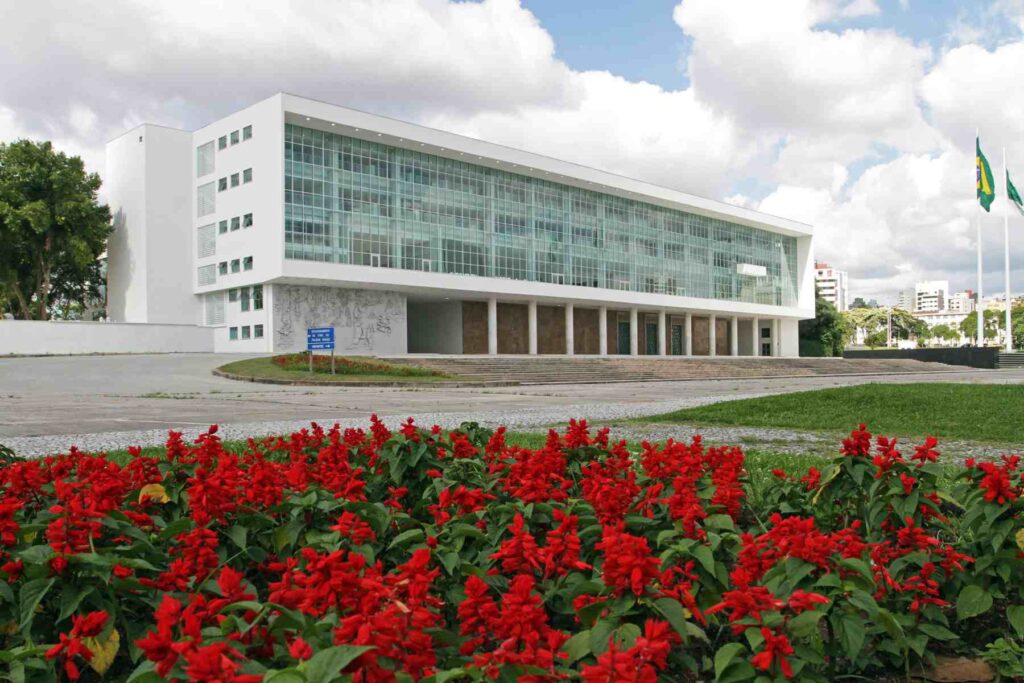 Palácio Iguaçu, sede do Governo do Paraná, visto a partir de um jardim florido com flores vermelhas