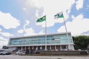 Palácio Iguaçu, sede do Governo do Paraná, visto de frente em meio às bandeiras paranaense e brasileira