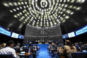 Vista interna do plenário do Senado Federal, focando nas luzes do teto, durante sessão especial de homenagem